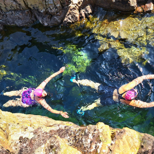 aerial view of 2 swimmers in a canyon.